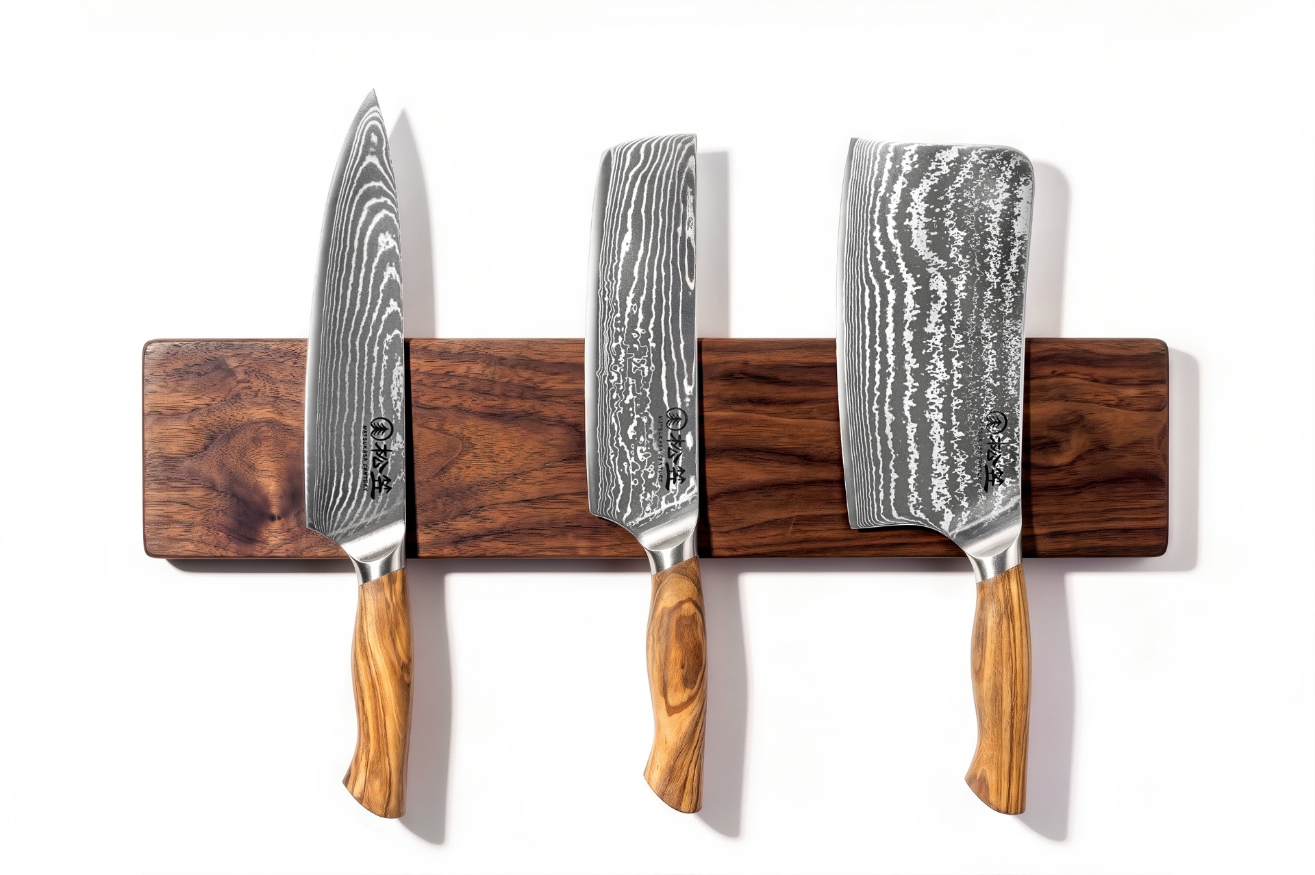 Three MATSUKASA Damascus steel knives resting on a walnut magnetic rack
